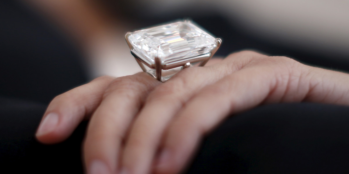 A woman displays a 100.20-carat diamond ring at a pre-auction viewing at Sotheby's in Los Angeles, California March 25, 2015. Sotheby's says the ring is expected to sell for US $19-25 million.