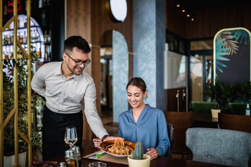 Konobar uslužuje ljude