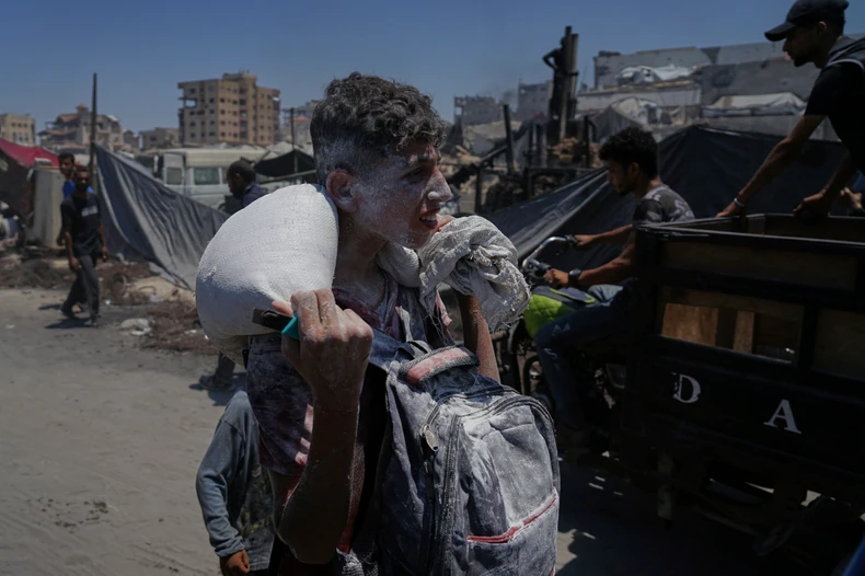 Palestinci nose pomoć iz humanitarnog konvoja koji je stigao u Gaza Siti sa severa enklave 22. jula