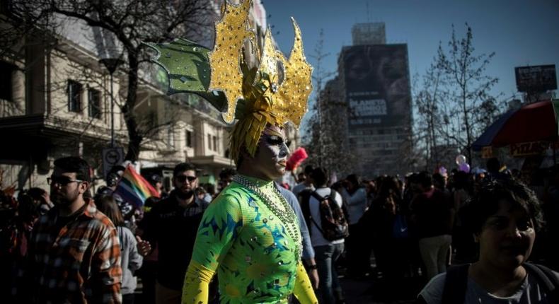 Carrying rainbow flags and banners, participants in Santiago's Gay Pride Parade, some dressed in drag, marched through the city's streets on July 1, 2017