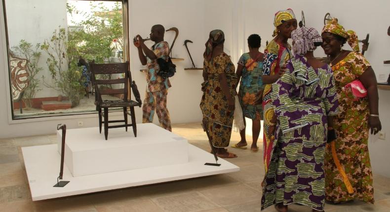 Visitors contemplate artefacts recently returned to Benin and on show at Cotonou's Petite Musée de la Recade