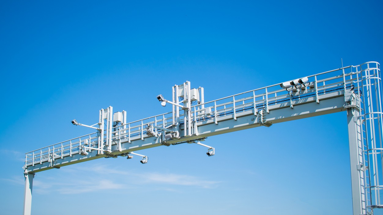 Moderný stacionárny radar umiestnený na mýtnej bráne nad diaľnicou. 