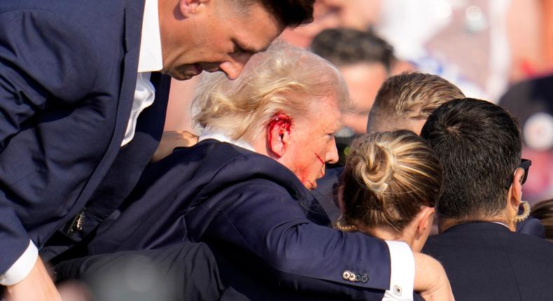 Former President Donald Trump was helped off the stage at a campaign event in Butler, Pa., on Saturday after loud pops were heard.Gene J. Puskar/AP