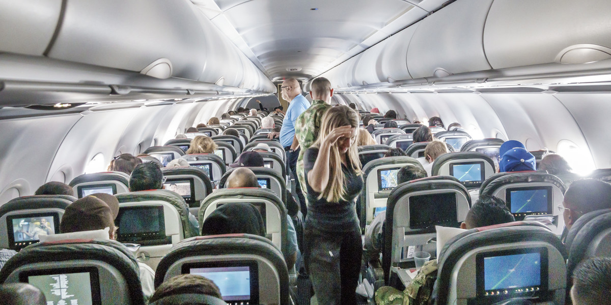 Miami, Floryda, pasażerowie American Airlines stojący w przejściu podczas lotu.
