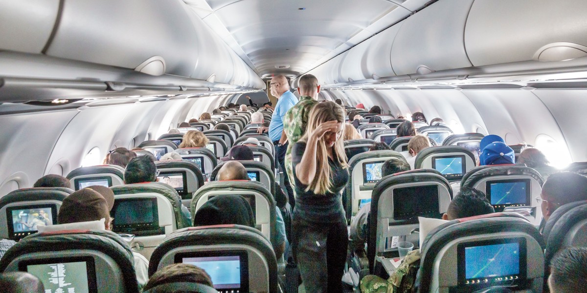 Miami, Floryda, pasażerowie American Airlines stojący w przejściu podczas lotu.