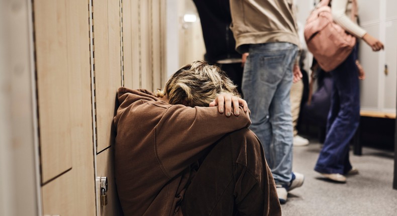 Picture of a girl crouched down in a school corridor.Maskot/Getty Images