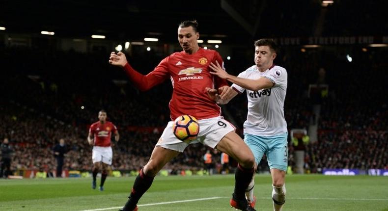 Manchester United's striker Zlatan Ibrahimovic (L) shields the ball from West Ham United's defender Aaron Cresswell (R) during the English Premier League football match between Manchester United and West Ham United on November 27, 2016