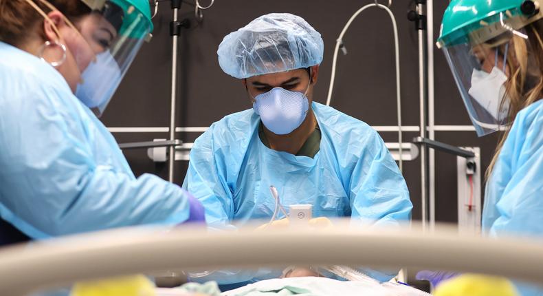 Clinicians work on intubating a COVID-19 patient in the ICU at Lake Charles Memorial Hospital in Lake Charles, Louisiana on August 10, 2021.
