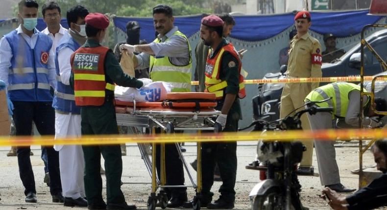 Pakistani security officials collect evidence from the scene of an attack on a census team in Lahore