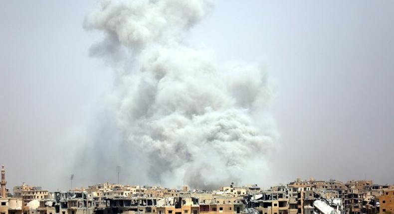 Smoke billows out from Syria's Raqa after a US-led coalition air strike on July 28, 2017, as US-backed forces battle the Islamic State group inside the city