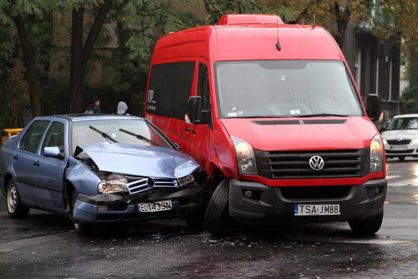 czerwony bus i niebieskie auto osobowe po wypadku