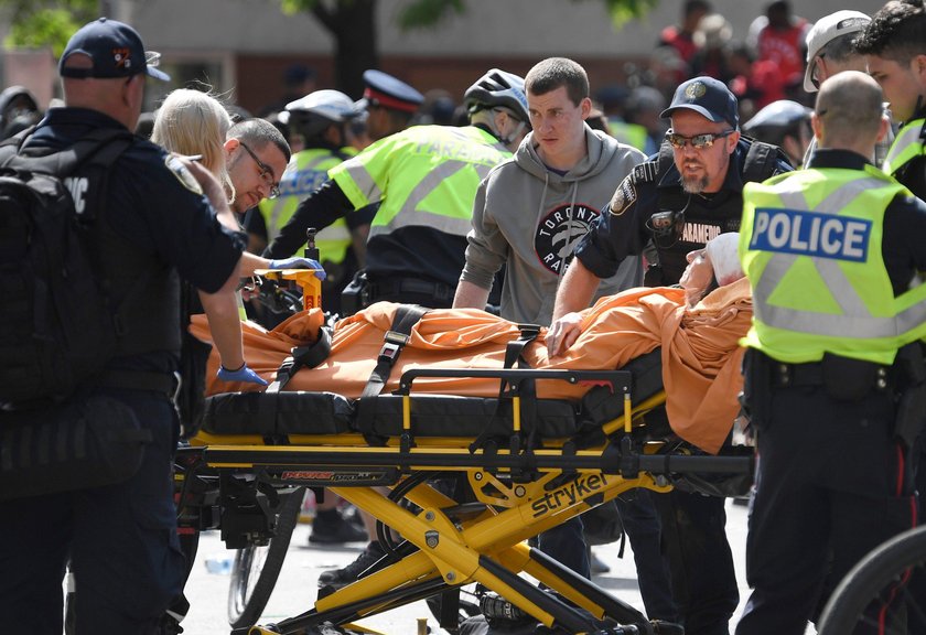 A crowd of people and police attend to the injured following a shooting during a victory celebration