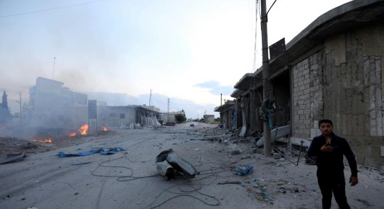 A man looks on at the site of a reported rocket attack by Syrian regime forces and their allies on the village of Kafr Nabl, south of the jihadist-held Syrian province of Idlib