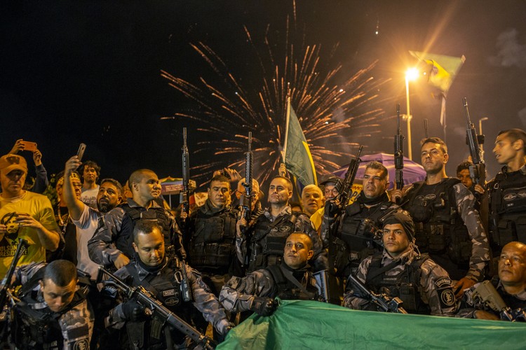 Milicja w Rio de Janeiro pozuje do zdjęcia na tle fajerwerków po ogłoszeniu wstępnych wyników drugiej tury wyborów prezydenckich w Brazylii.