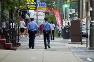 Philadelphia Police officers patrol a street.