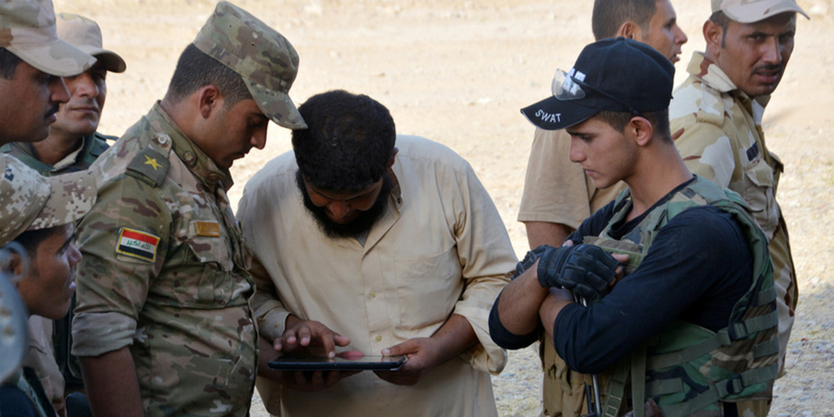 A displaced man from south of Mosul gives the coordinates of Islamic State militants to Iraqi soldiers south of Mosul.