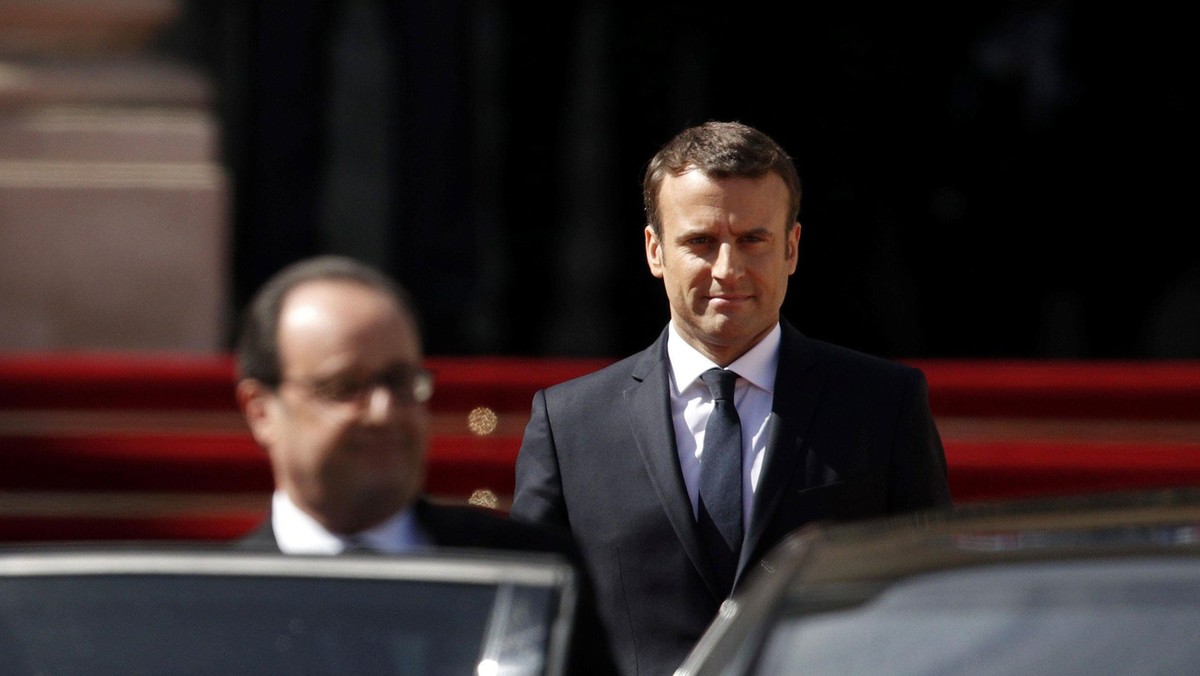 Former French President Francois Hollande leaves as President Emmanuel Macron watches after the hand