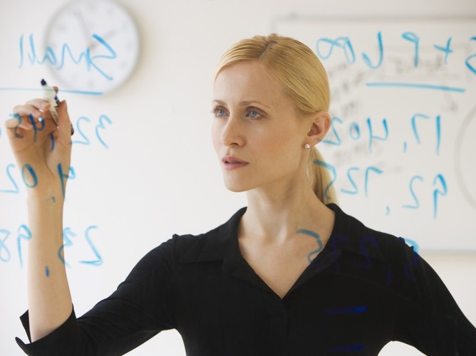 Najczęstsze błędy językowe związane z użyciem liczebnikówKobieta pisząca cyfry na tablicy