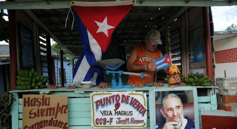 A farmer decorates his stall as he waits for the urn with the ashes of Cuban leader Fidel Castro to be driven through the streets of Las Tunas