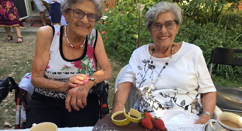 Twin concentration-camp survivors Stepa Heller, left, and Annetta Able, with their birthday cake in 2019. The inmate number that Heller was given at Auschwitz can be seen tattooed on her arm.Courtesy of Daphna Able