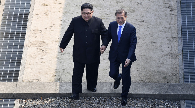 Kim Dzsong Un észak-koreai vezető (balra) és Mun Dzse In dél-koreai elnökkel lépi át a két Koreát elválasztó demarkációs vonalat /Fotó: MTI/AP/Korea-közi csúcs sajtószolgálata/pool