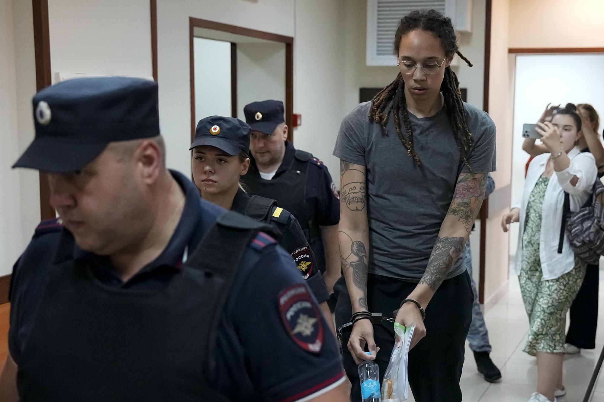 Americká basketbalistka Brittney Grinerová (uprostred) prichádza v putách do súdnej siene v Moskve.