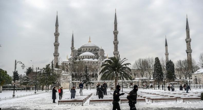 Turkish police officers patrol around the Blue mosque (Sultan Ahmet) during snowfall in Istanbul on January 8, 2017