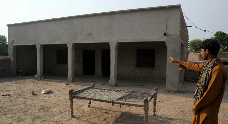 A Pakistani villager poses as he points to a house where a teenage girl was raped in the neighbourhood of Raja Ram in Muzaffarabad, a suburb of the central city of Multan