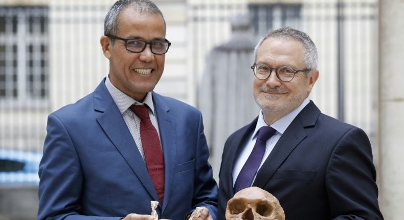 French paleoanthropologist Jean-Jacques Hublin (R) and Abdelouahed Ben-Ncer of the National Institute of Archaeology and Heritage Sciences in Morocco pose with the casting of a skull of Homo Sapiens discovered in Morocco on June 6, 2017 in Paris