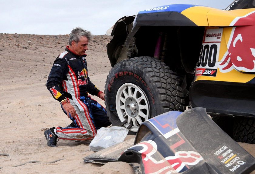 Driver Carlos Sainz, of Spain, and co-driver Lucas Cruz, of Spain, work on their Mini after it broke