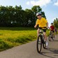 A happy family riding their bikes on a country road