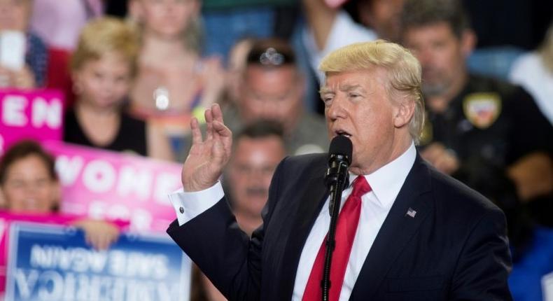 US President Donald Trump (C) speaks during a rally in Harrisburg, Pennsylvania marking his 100th day in office