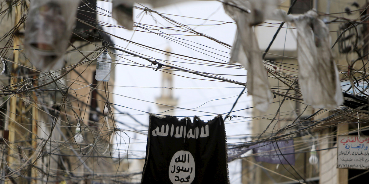 An Islamic State flag hangs amid electric wires over a street in Ain al-Hilweh Palestinian refugee camp, near the port-city of Sidon, southern Lebanon Jan. 19, 2016.