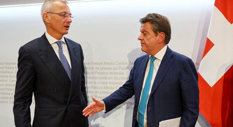 Colm Kelleher, the chairman of UBS, looks to shake hands with Axel Lehmann, his counterpart at Credit Suisse, on Sunday.Denis Balibouse/Reuters