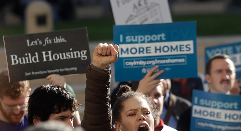 Housing protesters yell at a rally outside of City Hall in Oakland.
