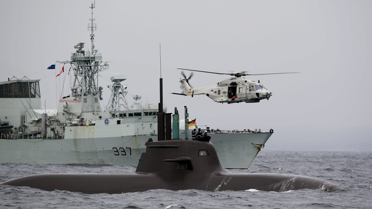 The German submarine U33, HMCS Fredericton of Canada and a helicopter of Netherlands participates in NATO's Dynamic Mongoose anti-submarine exercise in the North Sea off the coast of Norway