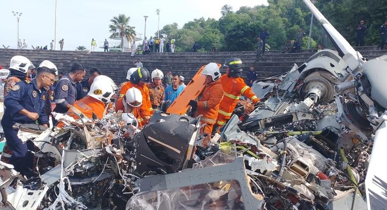 Rescuers work to move bodies at the wreckage of a crashed helicopter in Lumut.Bomba Bahagian Korporat/Facebook