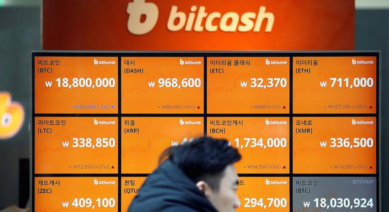 A man walks past an electric board showing exchange rates of various cryptocurrencies including Bitcoin (top L) at a cryptocurrencies exchange in Seoul, South Korea December 13, 2017REUTERS/Kim Hong-Ji