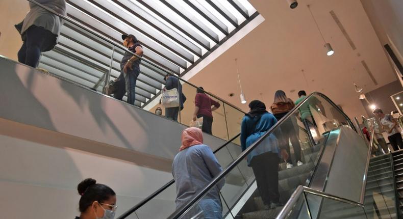 Shoppers wearing protective face masks  observe a safe distance at a clothing store in the Tunisian capital on May 12, 2020 following the easing of the lockdown measures put in place to combat the spread of coronavirus