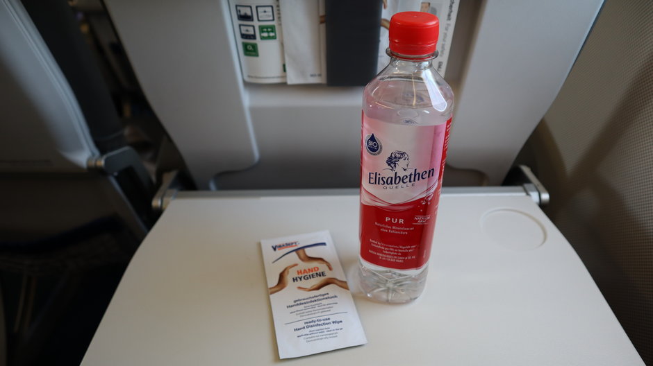 Woda i chusteczka do odkażenia dłoni na pokładzie samolotu Lufthansy