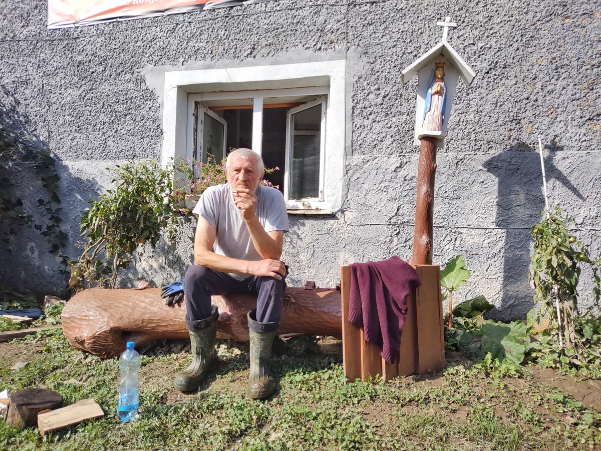 Rzeźbiarz Jan Giejson z Barda siedzi na powalonej przez wodę kapliczce