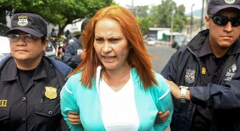 Marixa Lemus, alias La Patrona, from Guatemala is escorted by police as she is presented to the media after her arrest for allegedly heading a criminal network involved in kidnapping and murder, in San Salvador on May 25, 2017