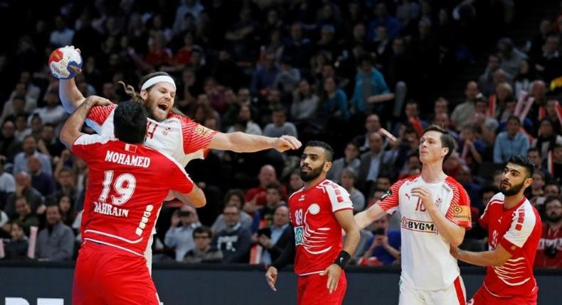 Bahrain's Mohamed Merza Salman (L) defends against Denmark'back Mikkel Hansen during their World Championship match on January 18, 2017 in Paris