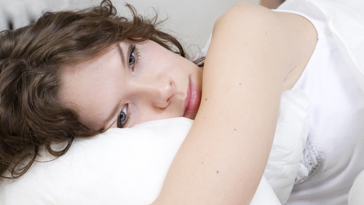 brunette curl woman lying on the bed