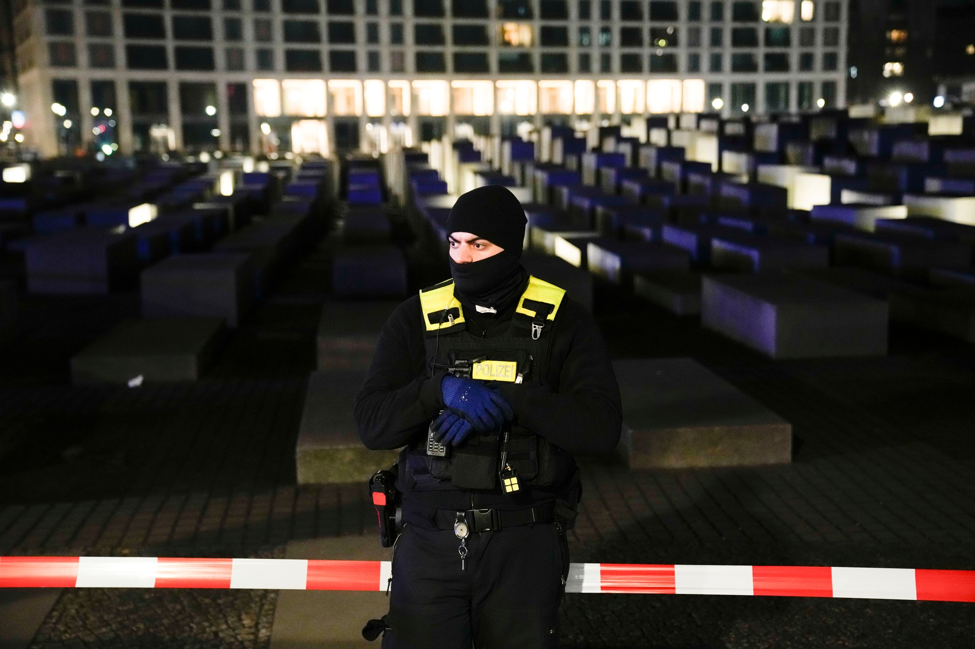 Policajt stráži ohradený pamätník holokaustu po útoku na muža na pamätnom mieste v Berlíne, Nemecko, piatok 21. februára 2025.