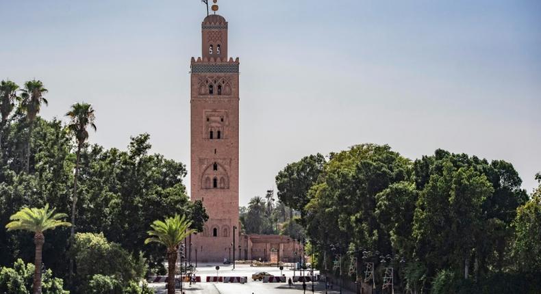 A few people walk by next to the Kutubiyya mosque's minaret tower at the Jemaa el-Fna square in the Moroccan city of Marrakesh on September 8, 2020, currently empty of its usual crowds due to the COVID-19 pandemic