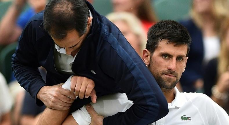 Novak Djokovic receives medical attention on court at Wimbledon