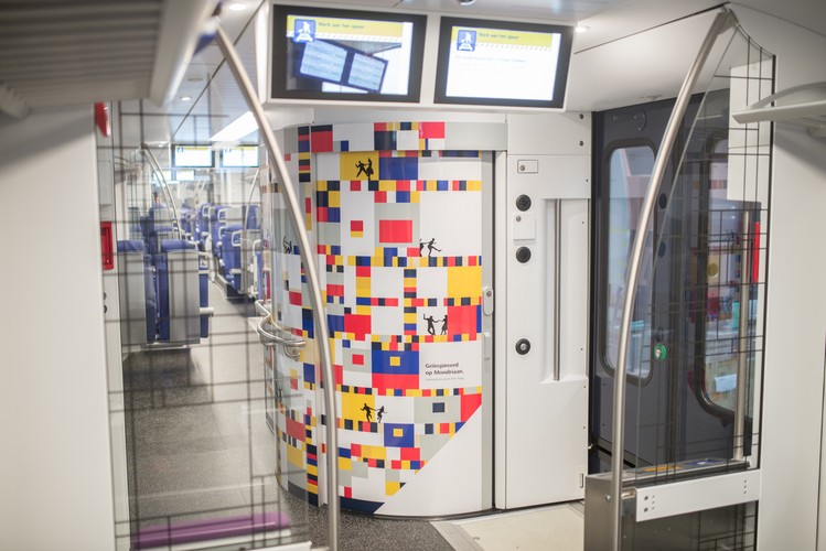 Pod sufitem podwieszone są ekrany systemu informacji pasażerskiej. Ale uwagę zwracają nie monitory, ale raczej ściana pod nimi. Przewoźnik podaje, że malowanie wewnątrz pojazdów jest inspirowane sztuką holenderskiego malarza Pieta Mondriana, który był przedstawicielem kierunku w sztuce o nazwie: abstrakcja geometryczna. Artysta zmarł w 1944 r.