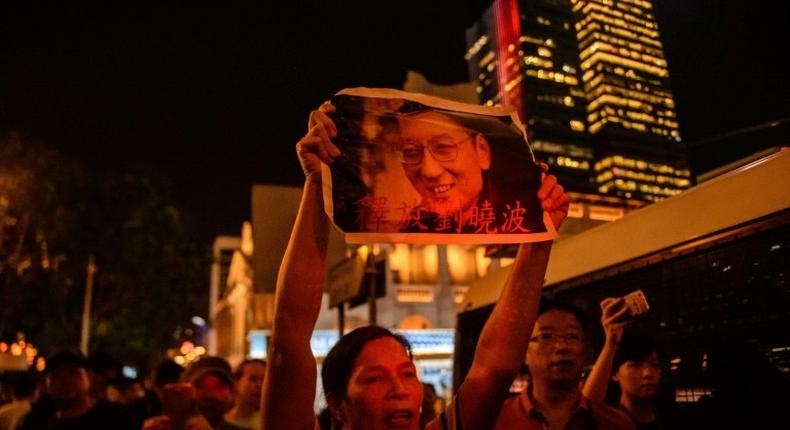 An activist holds a poster of terminally-ill Nobel laureate Liu Xiaobo on the sidelines of a vigil for him in Hong Kong on June 29, 2017.Liu wants Chinese authorities to let him get treatment abroad, friends say, as officials said his cancer has spread throughout his body. The Nobel Peace Prize winner, who was sentenced to 11 years in prison in 2009 for subversion after calling for democratic reforms, was released on medical parole after being diagnosed with terminal liver cancer last month, his lawyer said this week.