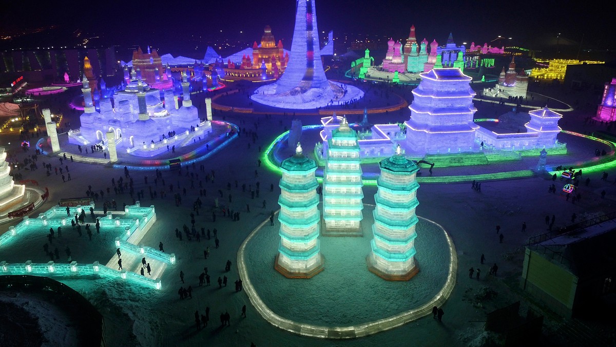 People visit ice sculptures illuminated by coloured lights during a trial operation of the upcoming Harbin International Ice and Snow Festival, in Harbin